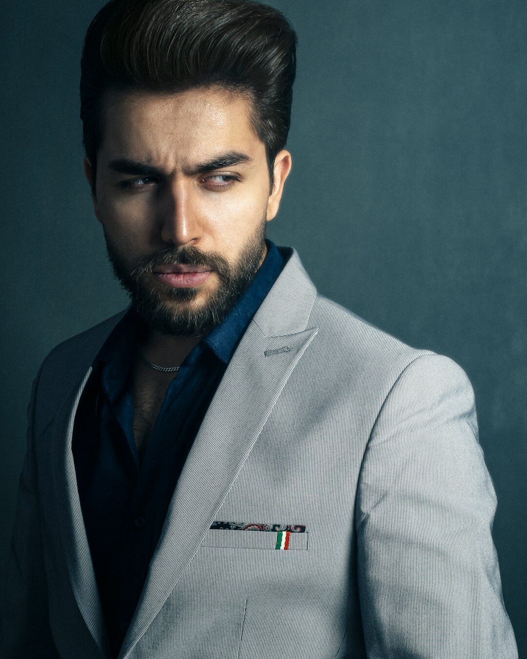 Studio portrait of a bearded man in a blazer